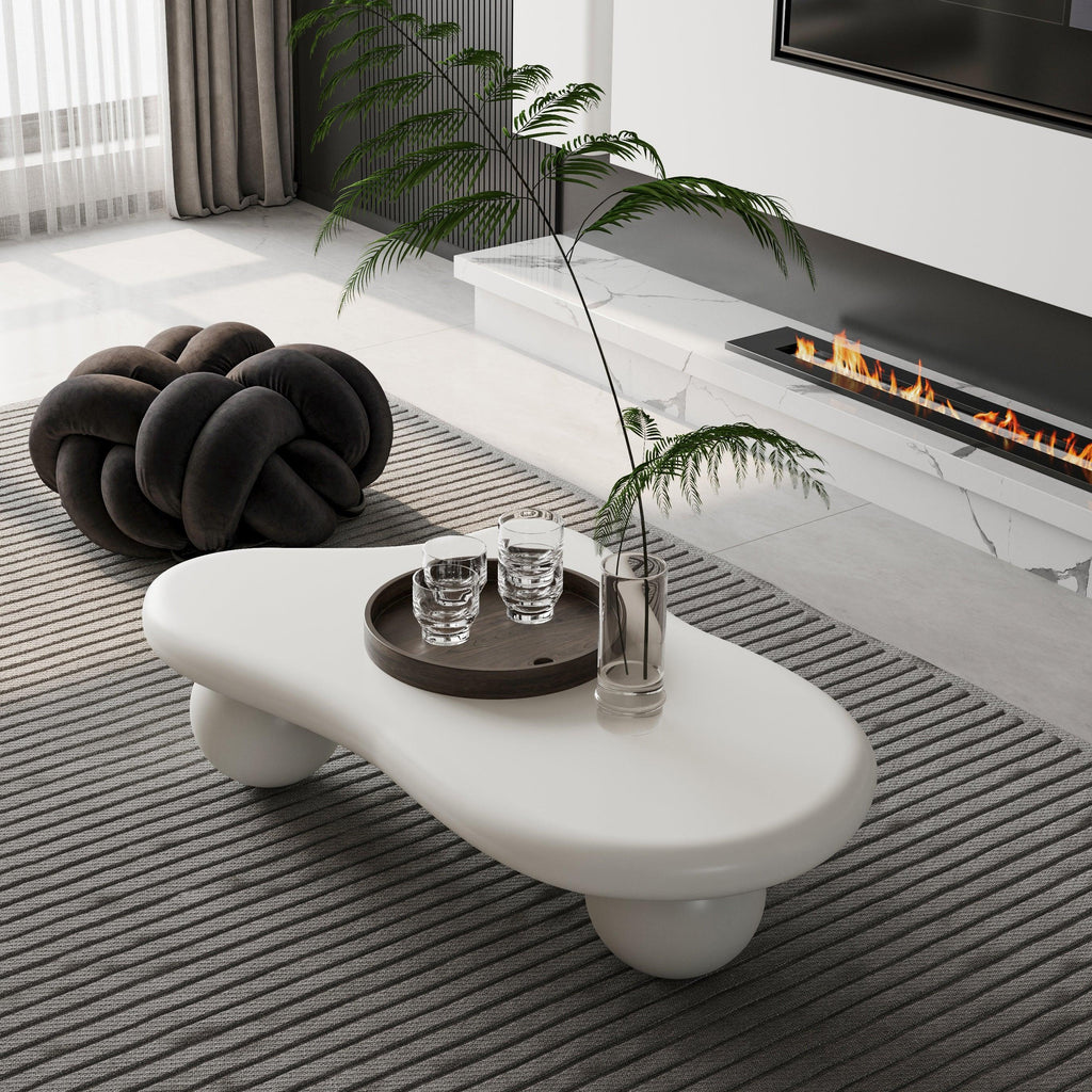 Modern living room with white modular coffee table, knot pouf, and contemporary fireplace