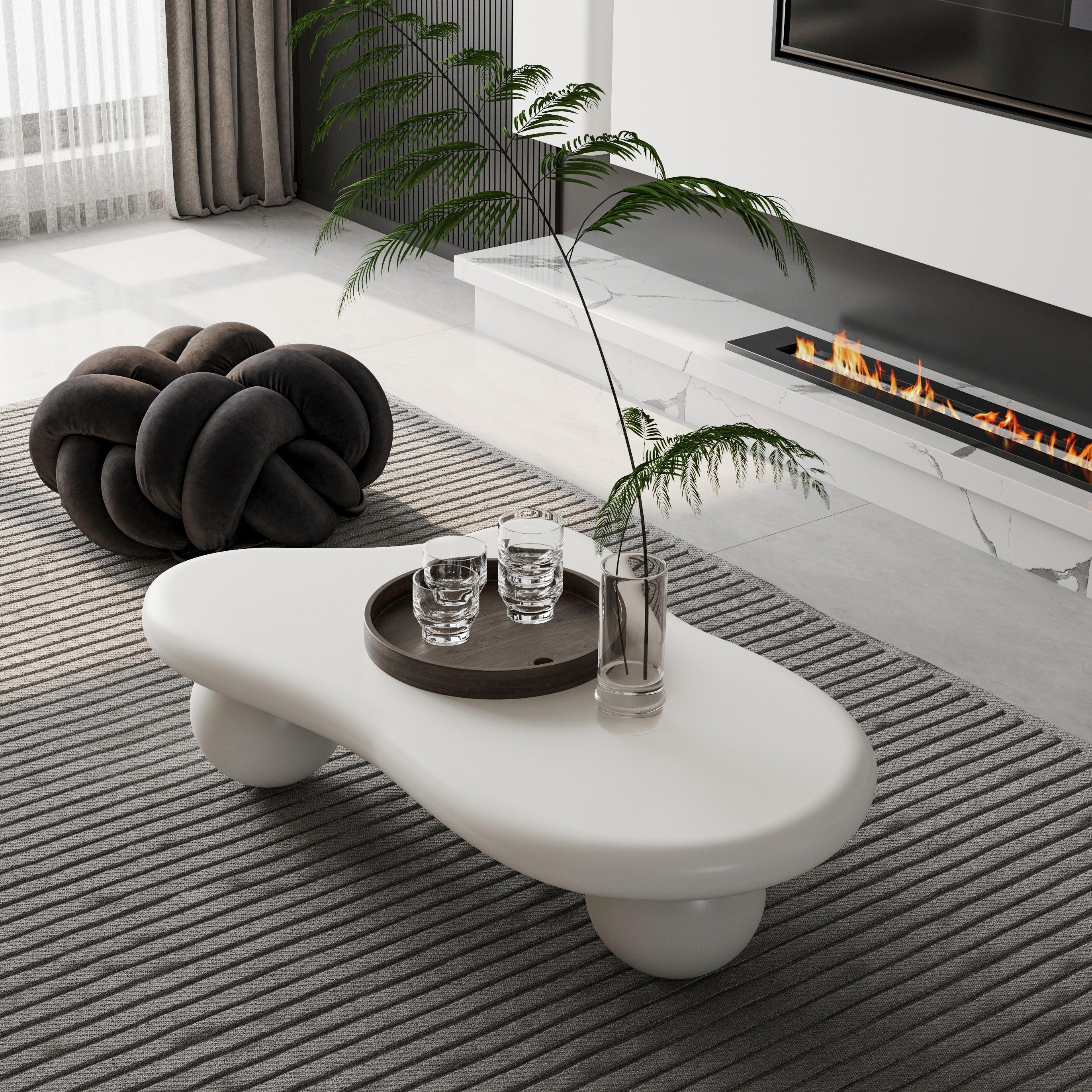 Modern living room with white modular coffee table, knot pouf, and contemporary fireplace