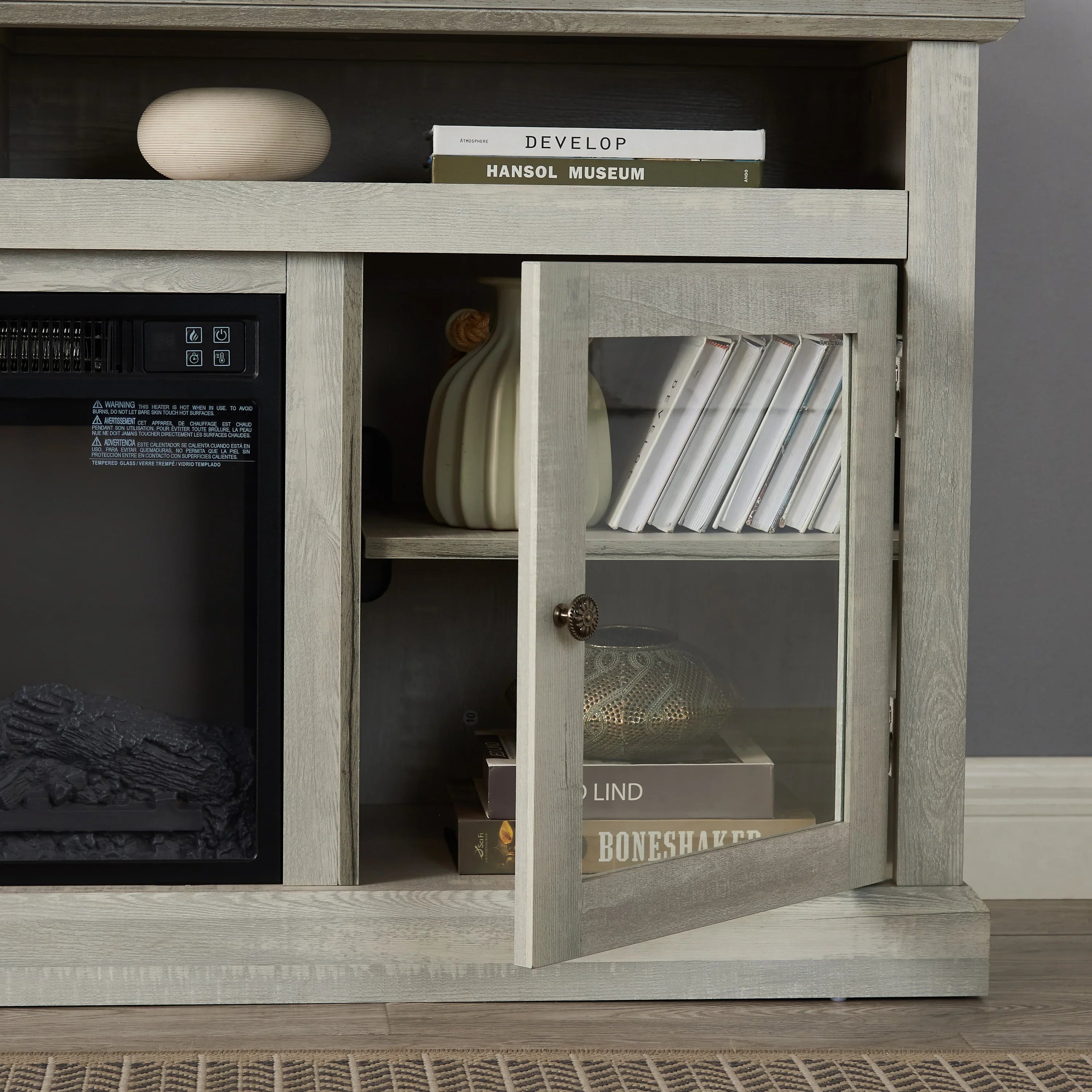 Modern wood cabinet with glass door, books, decorative vase, and minimalist decor in living room