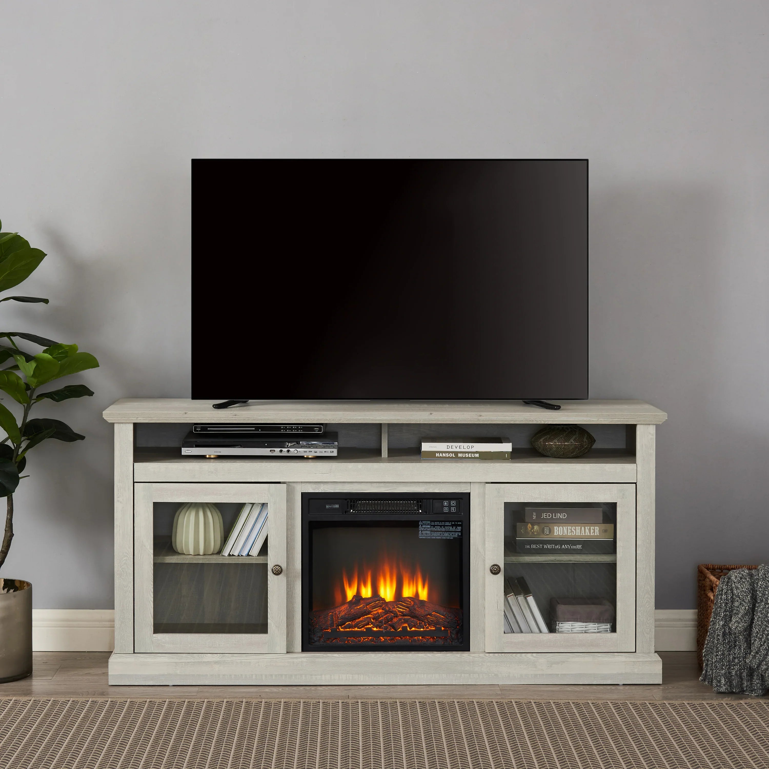 Modern living room with a TV on a light wood media console featuring an electric fireplace