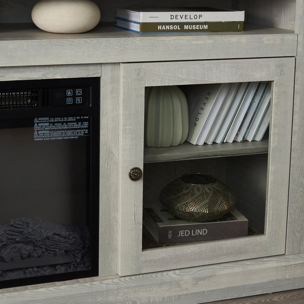Modern light wood cabinet with glass door, decorative books, vase, and metallic bowl.